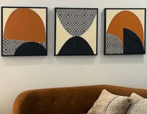 Abstract triptych of mound-like forms in brown, tan, black and grey.
